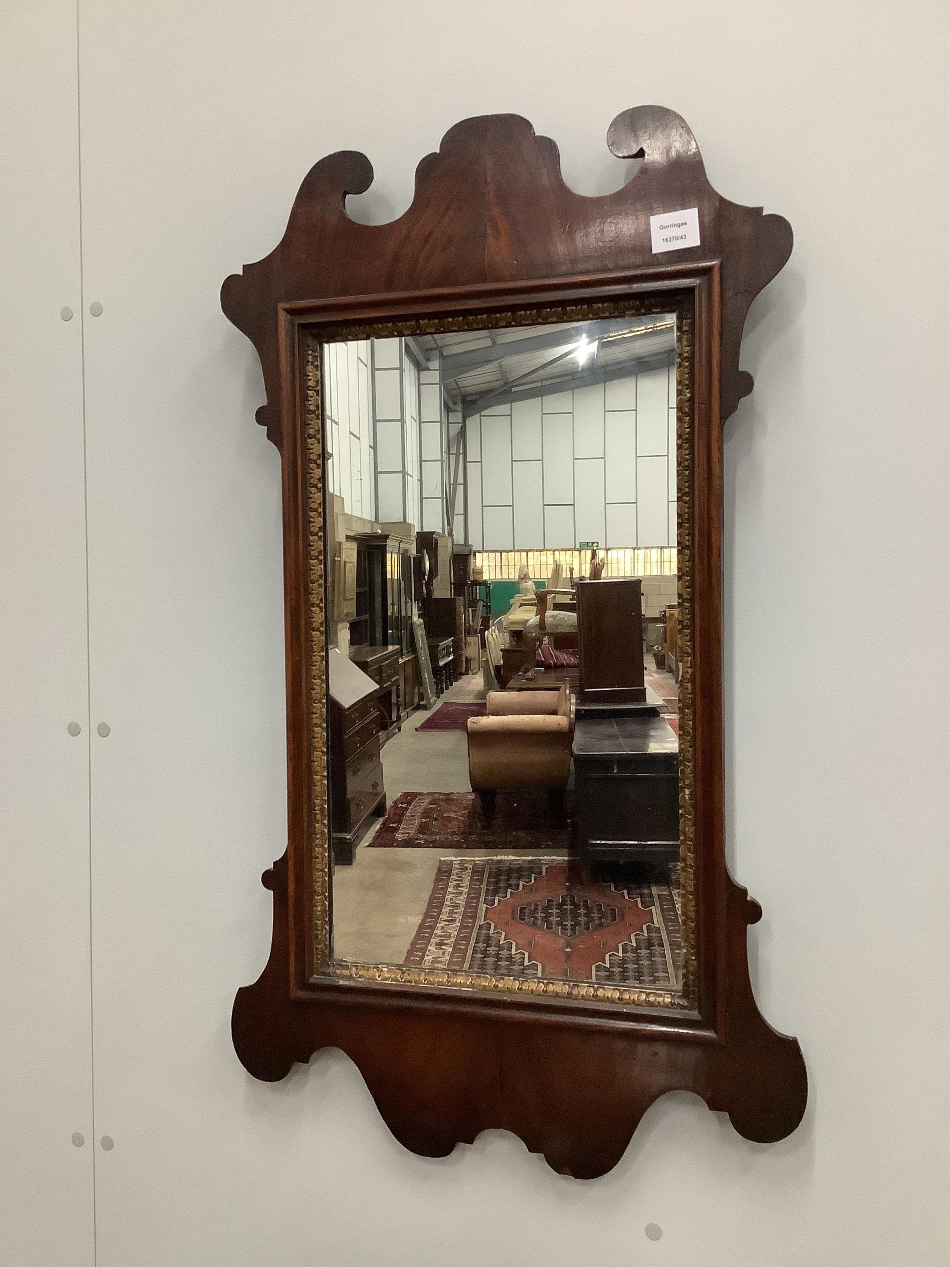 A George III style mahogany fret cut mirror, with a carved gilt slip, width 54cm, height 92cm. Condition - fair